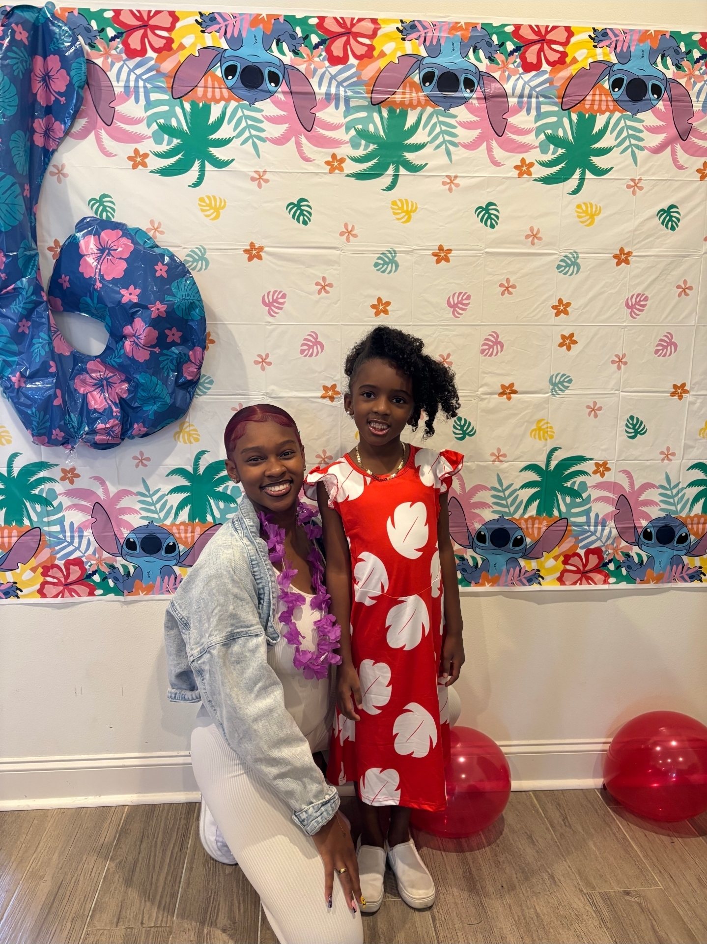 Dyimond kneeling next to her daughter at a Stitch-themed birthday party