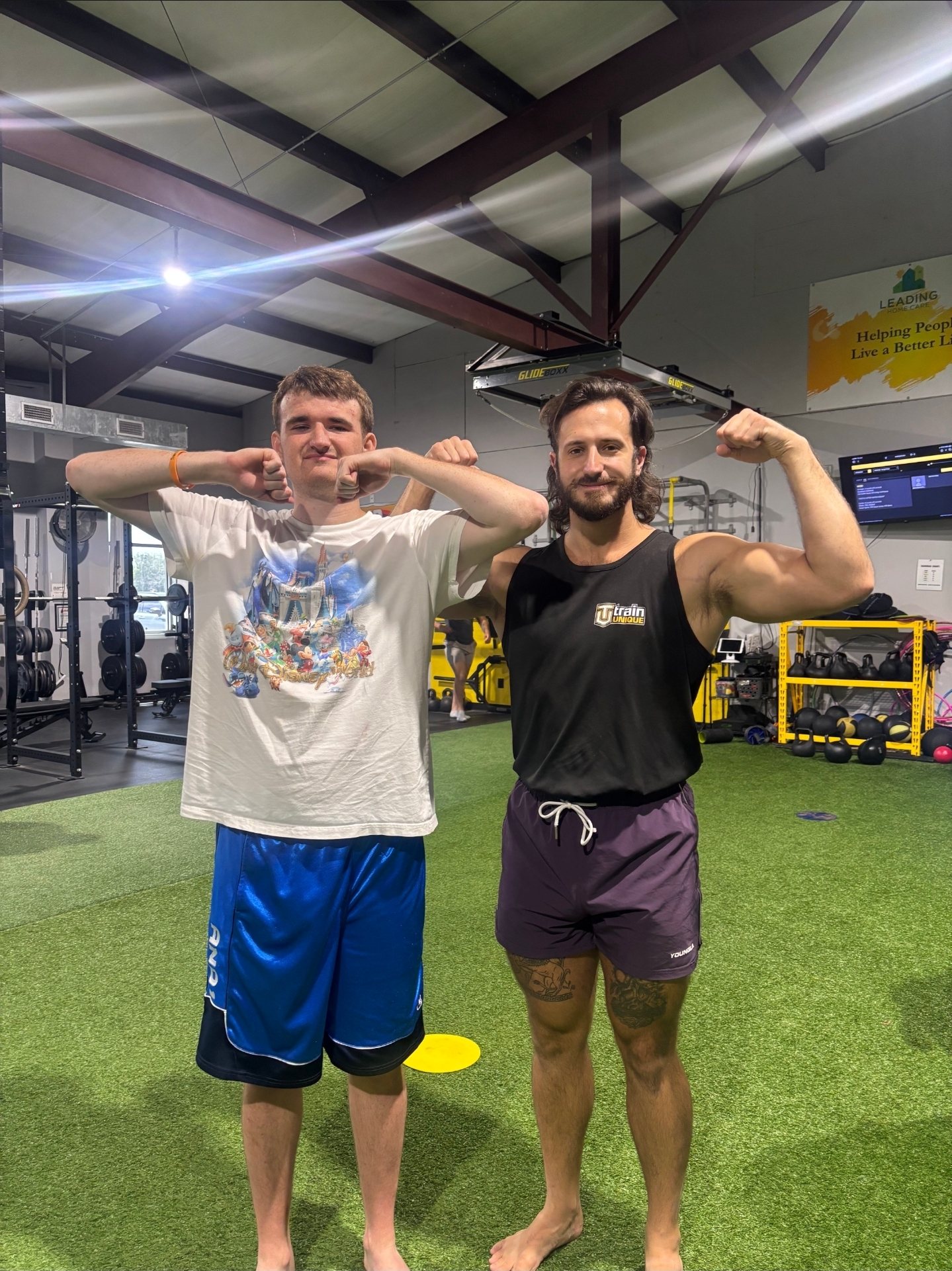 Garret and an athlete flexing together on the turf
