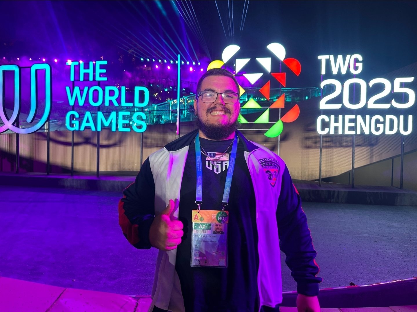 Jessie giving a thumbs up in front of The World Games 2025 Chengdu sign at night