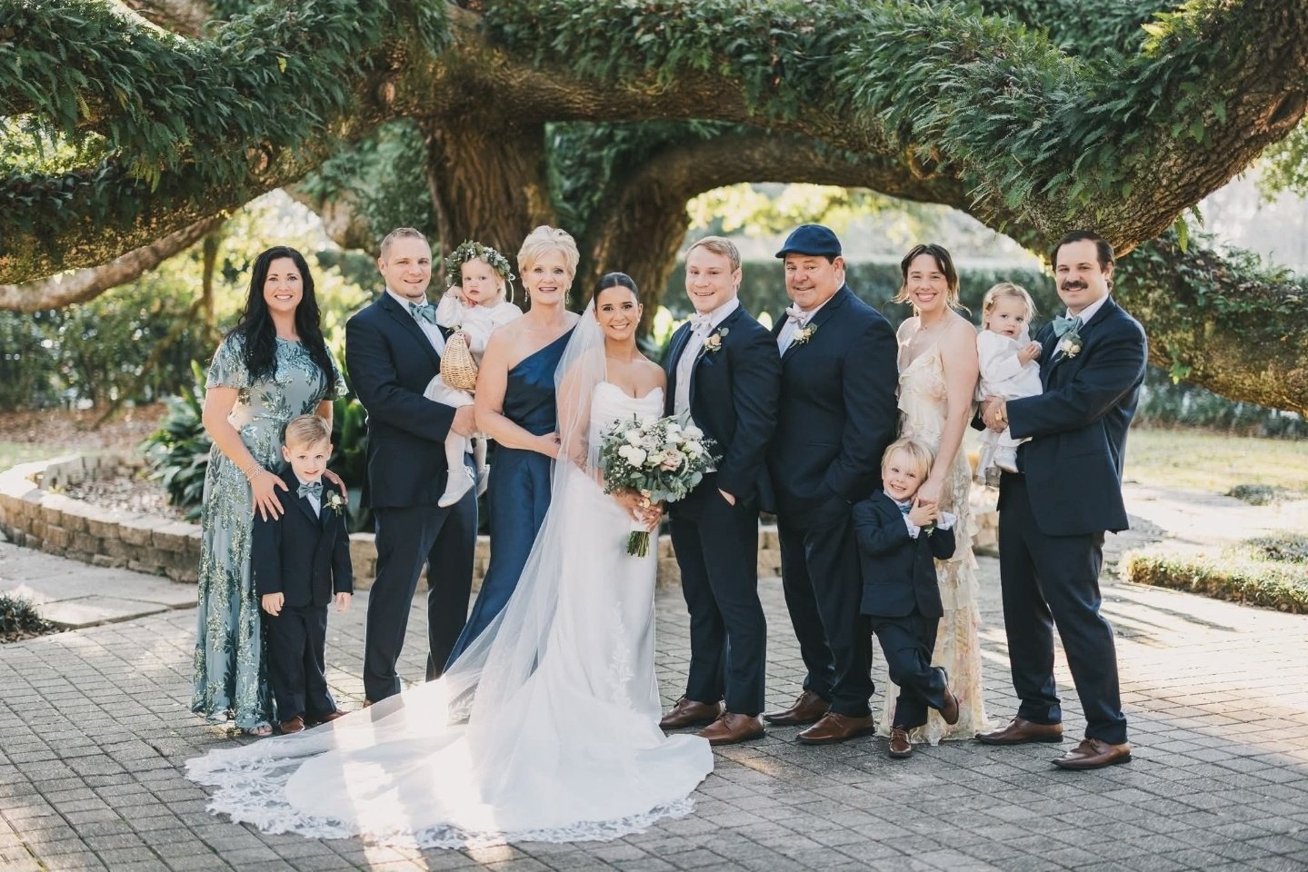 Paul in a flat cap at a wedding party under a live oak