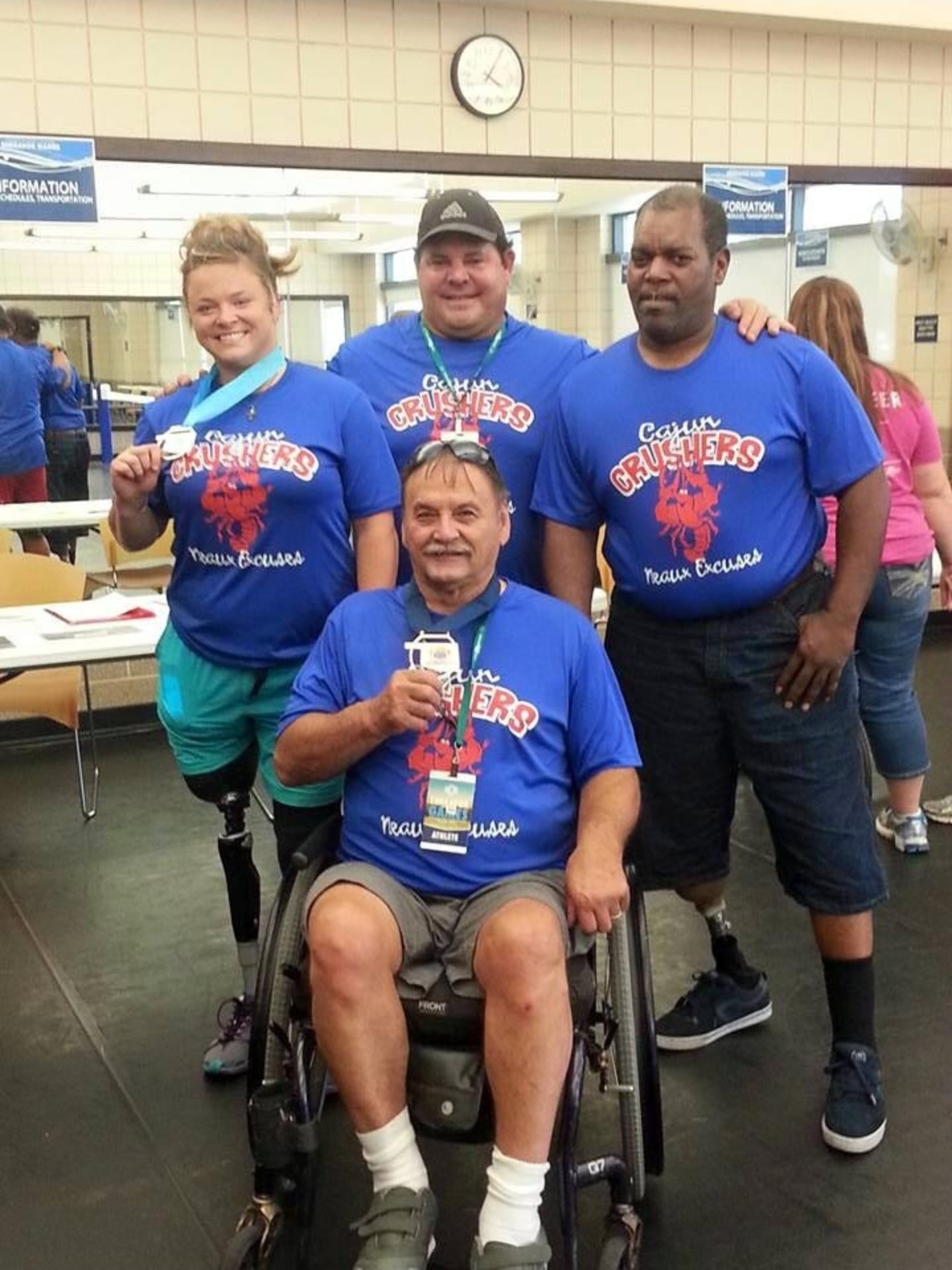 Paul with the Cajun Crushers team, athletes with prosthetics and a wheelchair around him