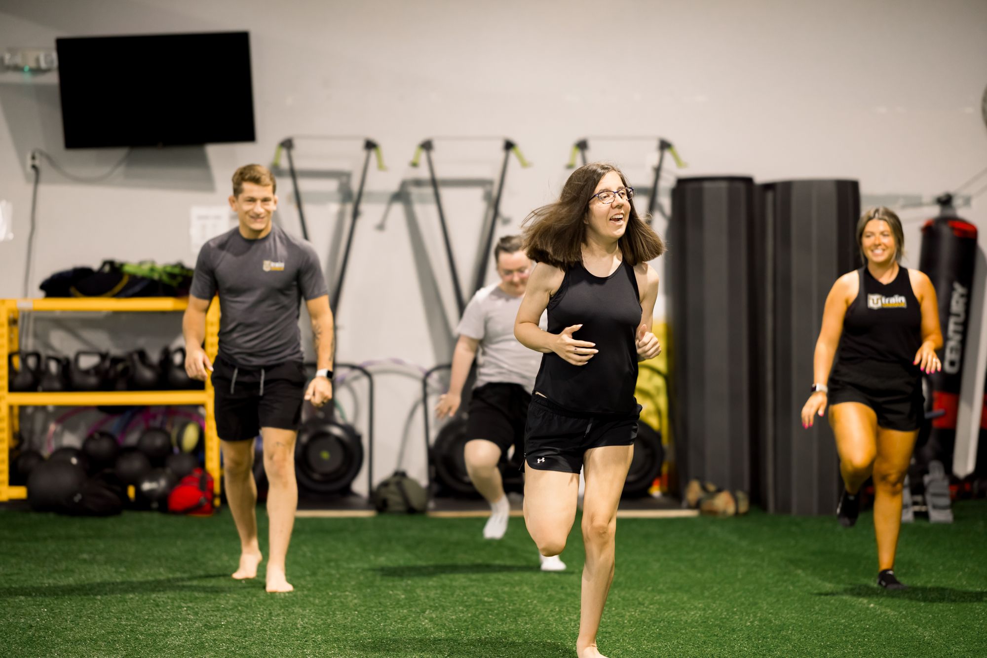 Coaches and athletes mid-run on the turf