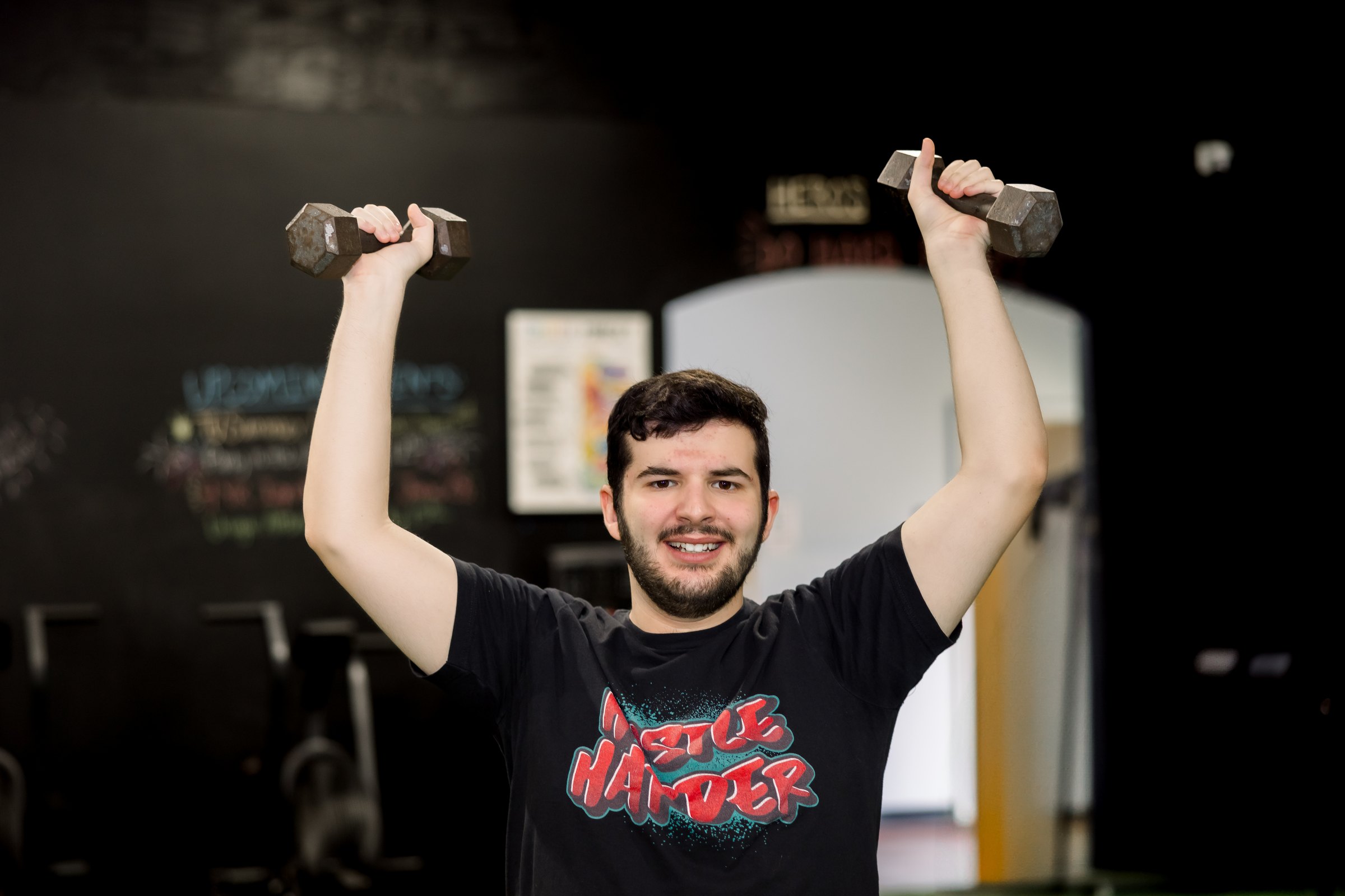 An athlete pressing dumbbells overhead
