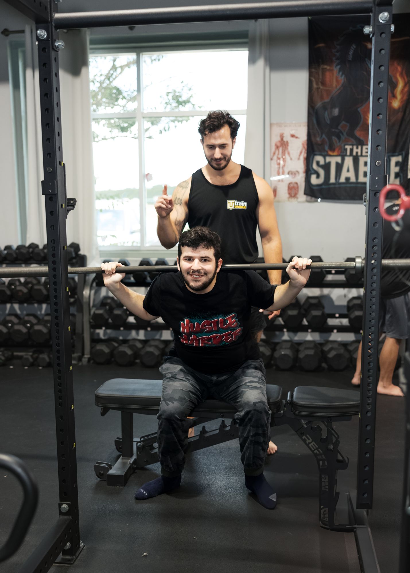 An athlete seated at the rack, ready to press