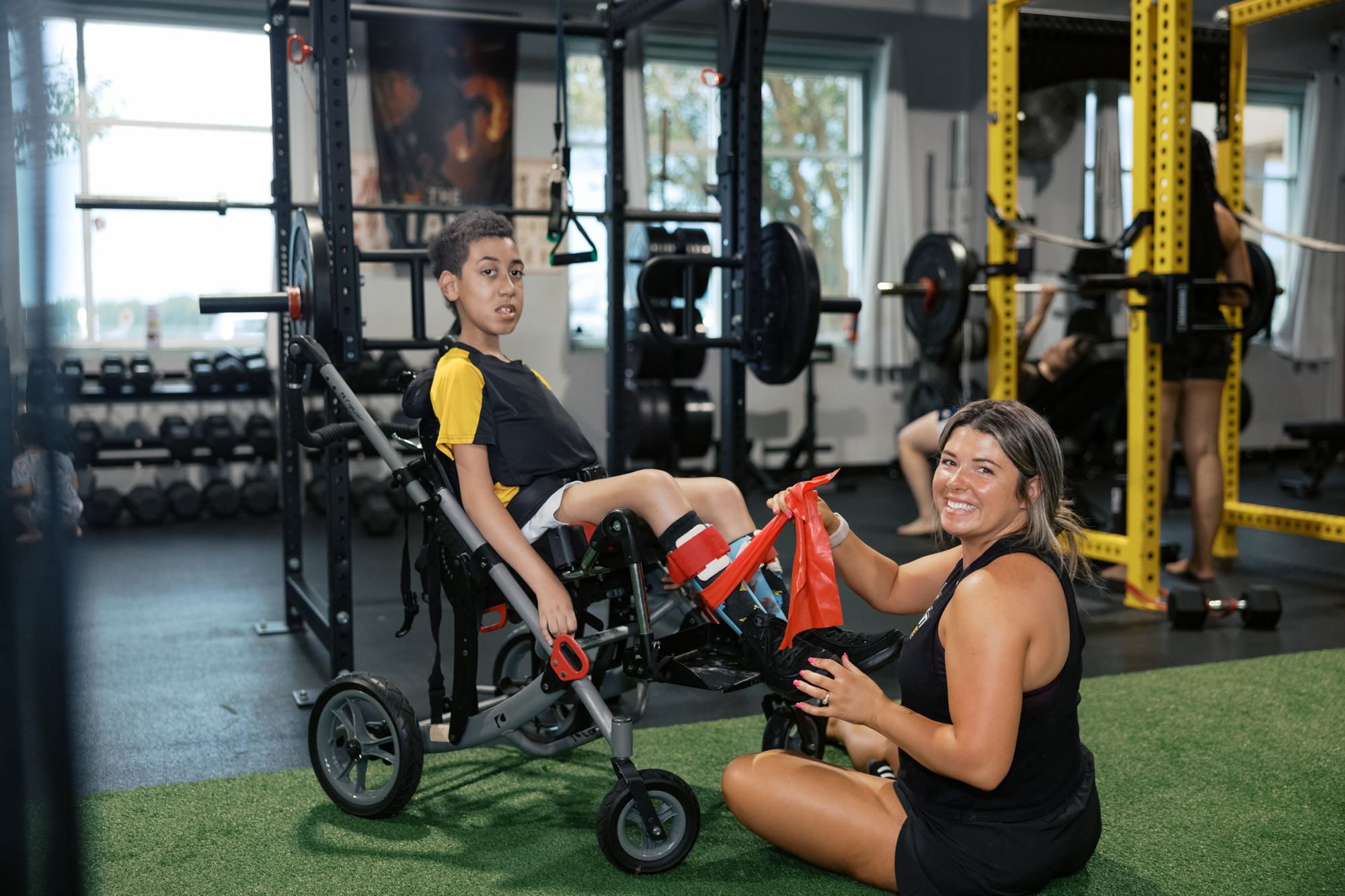 A coach on the floor beside her athlete's chair with the band